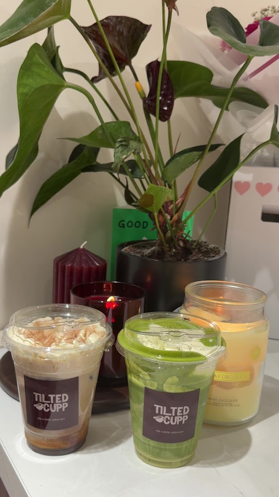 Iced coffee and matcha beside candles and plants